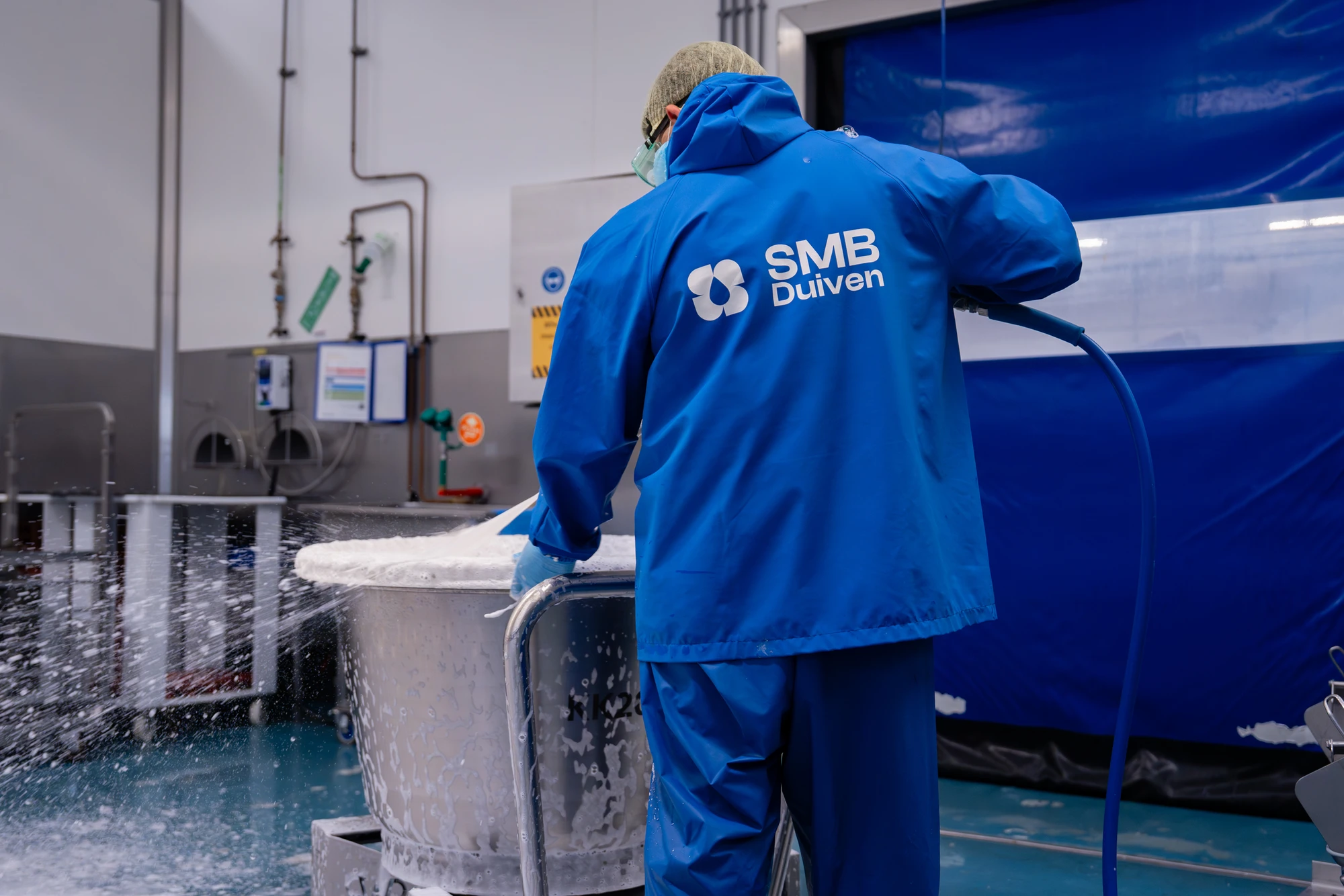 Medewerker van SMB Duiven reinigt een productielijn
