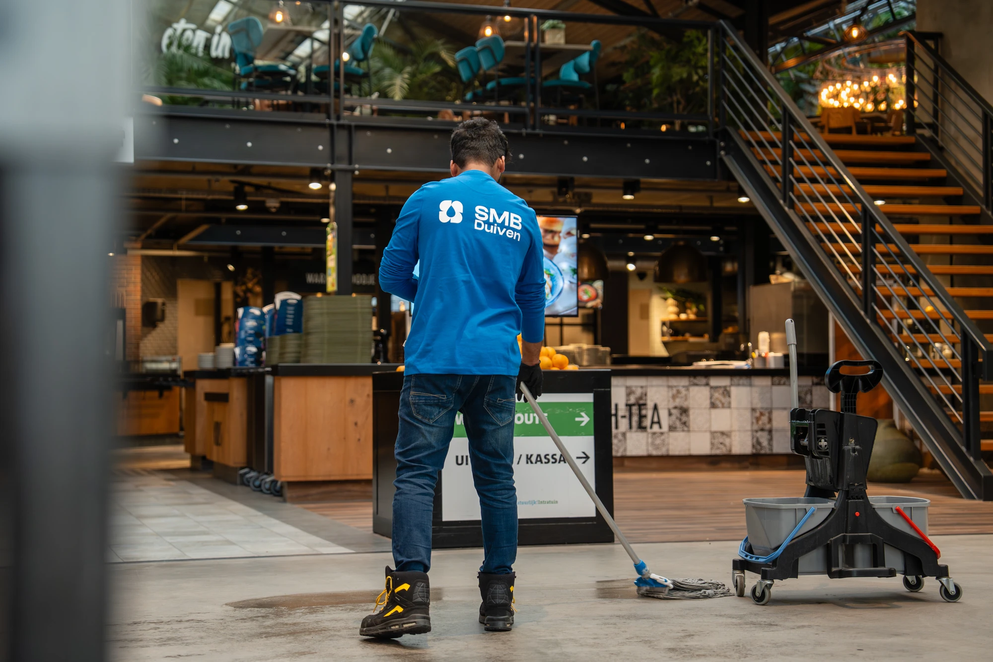 Medewerker van SMB Duiven maakt schoon in een winkel